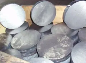 Metal discs stacked in a wooden crate.